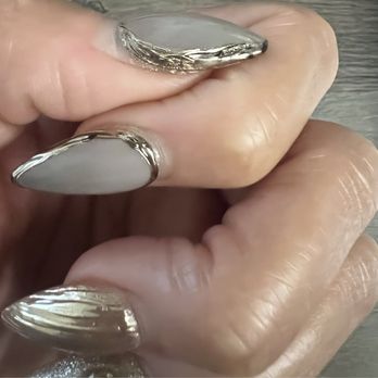 The X Nail - If you look in the photo around the perimeter of the nail, the chrome paint is chipping off and you see black. - Nail Salons Near Me - Ontario, California