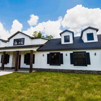 Rotunda Homes - This one story custom designed home built by Rotunda Homes features dormers, Hardie-Board, stone, and wooden entry posts. - General Contractors Near Me - Lutz, Florida