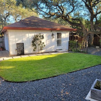 KG  - Small back yard with rock work, espaliered magnolia, pavers, and floating step. - Landscaping Near Me