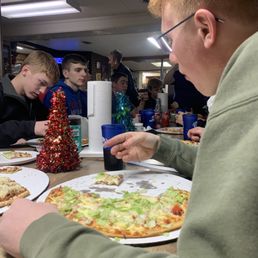a group of people eating pizza a group of people eating pizza