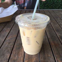 a man sitting at a table with a drink in a plastic cup