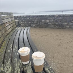 Two cold coffees sitting on a bench Two cold coffees sitting on a bench