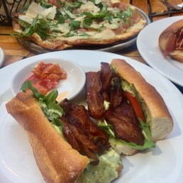 The quattro formaggi pizza and blt in the foreground The quattro formaggi pizza and blt in the foreground