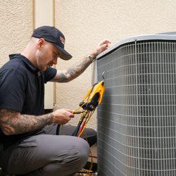 Three Guys Master Tradesmen - servicing an AC unit