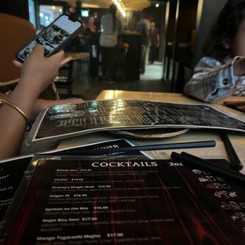 Shoku Izakaya - a woman sitting at a table with a menu - Asian Fusion Near Me - Banff, Alberta Shoku Izakaya - a woman sitting at a table with a menu - Asian Fusion Near Me - Banff, Alberta
