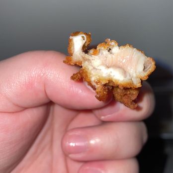 Chick-fil-A - ows a hand holding a half eaten sandwich - Fast Food Near Me - Goodyear, Arizona