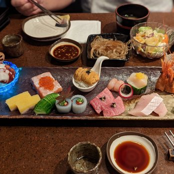 Gal's Sushi - A sushi platter featuring assorted sashimi, rolls, and garnishes, served on a dark rectangular plate with dipping sauces and side dishes. - Sushi Bars Near Me - Markham, Ontario