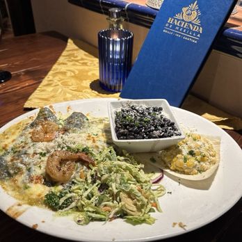 Hacienda de Mesilla - Blue crab enchiladas with green chile sauce garnished with 2 shrimp, corn tamale, black beans, salad, wine list with restaurant logo. - Seafood Near Me - Mesilla, New Mexico