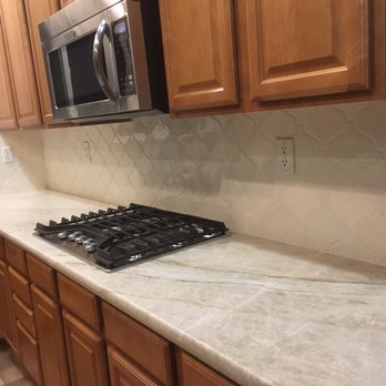 JTL Tile - a kitchen counter with a stove and microwave - General Contractors Near Me