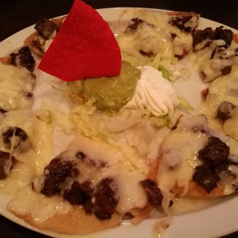 Sylvia's Enchilada Kitchen - Beef fajita nachos with a stale red chip in the middle - Mexican Near Me - Houston, Texas Sylvia's Enchilada Kitchen - Beef fajita nachos with a stale red chip in the middle - Mexican Near Me - Houston, Texas