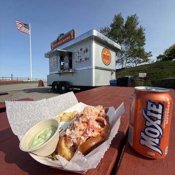 Bite Into Maine - Connecticut lobster roll with side of wasabi mayo and Moxie soda in front of the food trailer - Seafood Near Me - Cape Elizabeth, Maine Bite Into Maine - Connecticut lobster roll with side of wasabi mayo and Moxie soda in front of the food trailer - Seafood Near Me - Cape Elizabeth, Maine