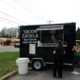 two people standing in front of a food truck two people standing in front of a food truck