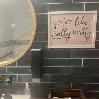 Sultan's Restaurant & Lounge - This picture shows the beautifully designed restroom along with floral arrangement and motivational artwork on the wall. - Mediterranean Near Me - Charleston, South Carolina