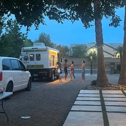a group of people standing in front of a food truck