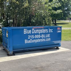 Blue Dumpsters - 10 Yard - dropped off with pads under the contact points and slightly elevated on one side to make any rain drain out