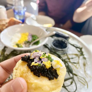 The Ordinary - a person holding a pastry with cavia on it - Seafood Near Me - Charleston, South Carolina