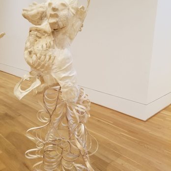 The Phillips Collection - Domestic abuse sculpture exhibit - A white sculpture of a human torso with detailed musculature and anatomical features is displayed in an art gallery. The sculpture has an abstract, curly base made of layered, ribbon-like material, creating a contrast with the realistic upper part. The setting includes a wooden floor and plain white walls, typical of a museum or gallery environment. - Art Museums Near Me - Washington, DC, District of Columbia