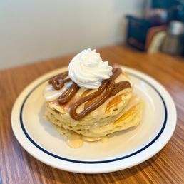 a plate of pancakes with whipped cream and chocolate sauce