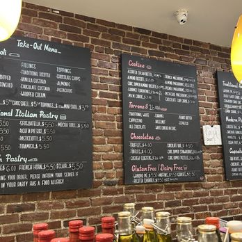 Modern Pastry Shop - Two black chalkboard menus list bakery items and prices, mounted on a brick wall in a bakery or cafe setting. - Bakeries Near Me - Boston, Massachusetts