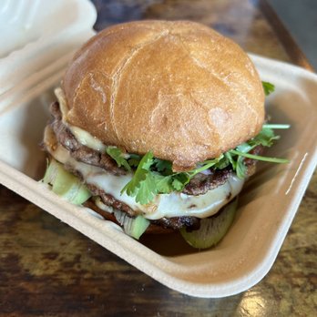 Taurus Ox - Burger: Two smash-patties around provolone cheese and jaew tomato with cured pork belly, jaew bong mayo, pickled red onions, taro stem - Laotian Near Me - Seattle, Washington
