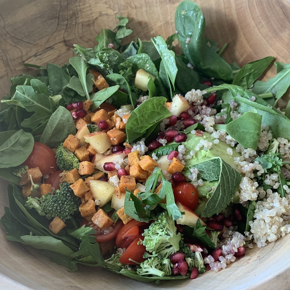 a wooden bowl filled with a salad