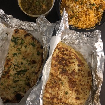 Punjab Cafe - Clockwise from top right: chicken biryani, aloo parantha, garlic naan, and hot lamb saag - Indian Near Me - Quincy, Massachusetts