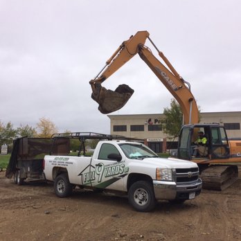 Full 9 Yards - the back end of a truck with a large excavator in the back of it - Lawn Services Near Me