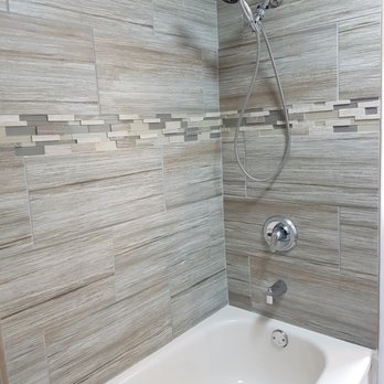 Leading Construction - a bathtub and shower in a bathroom - General Contractors Near Me
