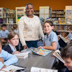 Saint Thomas More Catholic School - Intermediate students peruse books they've checked out in the media center.