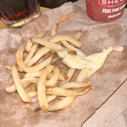 Cup of fries with a glob of unwanted cheese in the bottom.