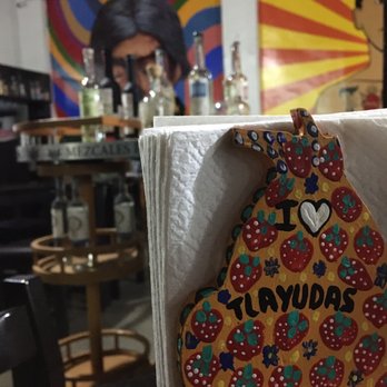 I Love Tlayudas - Everything Oaxaca in one photo from front to back: tlayuda love, mezcal, wall art of an Oaxacan abuela (grandma). - Tacos Near Me - Oaxaca, OAX I Love Tlayudas - Everything Oaxaca in one photo from front to back: tlayuda love, mezcal, wall art of an Oaxacan abuela (grandma). - Tacos Near Me - Oaxaca, OAX