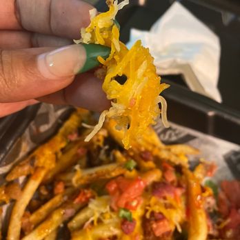 Smokey Bones - a hand holding a piece of food - Barbeque Near Me - Greensboro, North Carolina Smokey Bones - a hand holding a piece of food - Barbeque Near Me - Greensboro, North Carolina