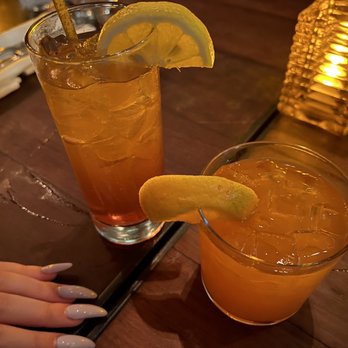 Grinder - a woman's hand and a glass of orange juice - Steakhouses Near Me - Montreal, Quebec