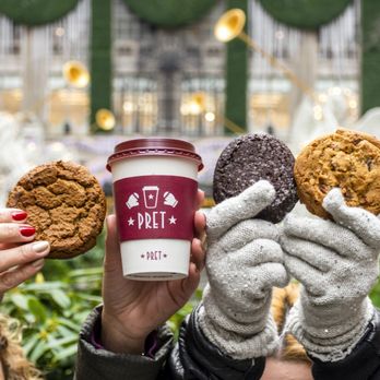 Pret A Manger - a woman holding a cup of coffee and two cookies - Coffee & Tea Near Me - Newark, Delaware Pret A Manger - a woman holding a cup of coffee and two cookies - Coffee & Tea Near Me - Newark, Delaware