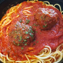 Genova's To Go - A hearty bowl of spaghetti and meatballs, garnished with fresh herbs and a rich tomato sauce from Genova's To Go.