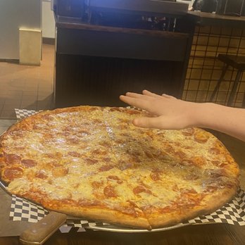 New York Pizza and Pints - Pie with a hand for size - Pizza Near Me - Carrollton, Texas New York Pizza and Pints - Pie with a hand for size - Pizza Near Me - Carrollton, Texas