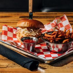 Kickin' Chicken Sandwich with cheddar, sweet crispy slaw, and zesty pickle. Crunchy, tangy, perfect!