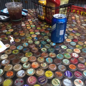 Twisted Root Burger - High bar tables topped with bottle caps - Burgers Near Me - Dallas, Texas Twisted Root Burger - High bar tables topped with bottle caps - Burgers Near Me - Dallas, Texas