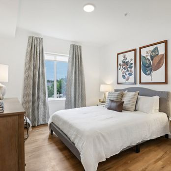 The Mill on Maple Apartments - a bedroom with a bed and a dresser and a window at The Mill on Maple Apartments, Oregon City, 97045 - Apartments Near Me - Oregon City, Oregon The Mill on Maple Apartments - a bedroom with a bed and a dresser and a window at The Mill on Maple Apartments, Oregon City, 97045 - Apartments Near Me - Oregon City, Oregon