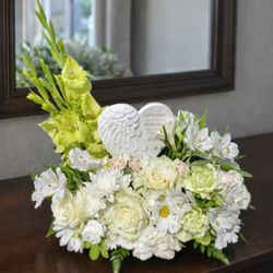 This serene design features pure white florals and an angelic touch, offering comfort during life's most difficult moments.
