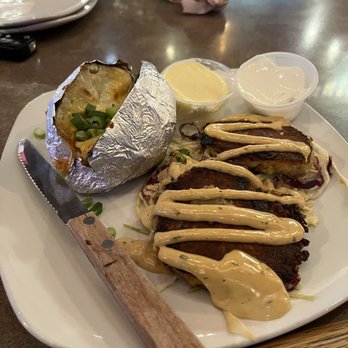 Sahm's Place - Part of the Surf & Turf weekly special - two crab cakes on top of chipotle slaw w/loaded baked potato - American Near Me - Indianapolis, Indiana
