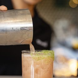 Shorebird - Smiling bartender creating a fresh craft cocktail with exceptional hospitality and care at Shorebird in Newport Beach.