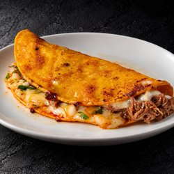 Fuego Cravings - 6" corn tortilla taco, filled with melted cheese, tender birria, fresh onion, and cilantro.