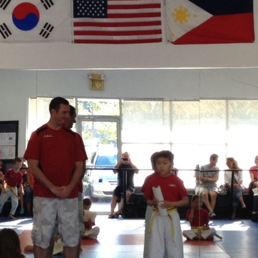 True Martial Arts - Alex thanking his instructors with advanced yellow belt - Martial Arts Near Me - Sammamish, Washington True Martial Arts - Alex thanking his instructors with advanced yellow belt - Martial Arts Near Me - Sammamish, Washington