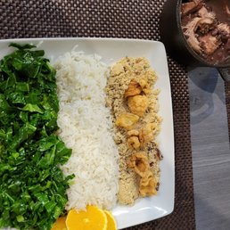 a plate of rice, chicken, and greens