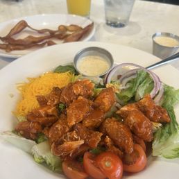 Buffalo Chicken Salad w/Caesar dressing and a side of bacon and a tall glass of orange juice Buffalo Chicken Salad w/Caesar dressing and a side of bacon and a tall glass of orange juice