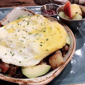 First Watch - Hash Bowl containing peppers, sausage, avocado, potatoes, and eggs over hard. Side of fruit and toast to contrast the savory flavors. - Breakfast & Brunch Near Me - Johnson City, Tennessee
