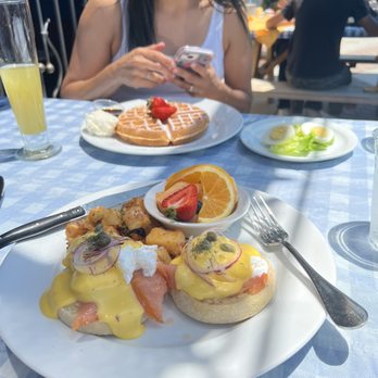 Immigrant Son Caffe - Friends waffled and pineapple mimosa in back ground - New American Near Me - Ventura, California Immigrant Son Caffe - Friends waffled and pineapple mimosa in back ground - New American Near Me - Ventura, California