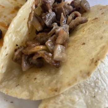 MOCAMBO - Buche - A taco with a soft, lightly toasted tortilla filled with cooked, diced meat, shown in close-up. - Mexican Near Me - El Paso, Texas