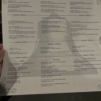The Cellar - a hand holding a menu - The menu from The Cellar in Peabody, MA, displays sections for wine, cocktails, and food. It features drinks such as French 75, Knickerbocker, and a selection of wines from France and California, along with food options like duck, salmon, and pasta. The menu is printed on a white sheet with decorative corner accents. - Bars Near Me - Peabody, Massachusetts